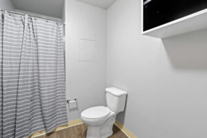 a bathroom with a toilet and shower curtain