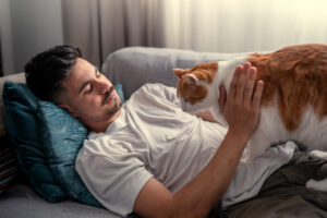 a man lying on a couch with a cat