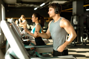 a man and woman running on treadmills