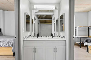 a bathroom with white cabinets and mirrors
