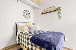 a bed with a blue blanket and pillows