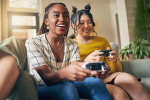 a group of women sitting on a couch playing video games