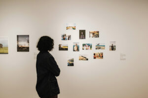 a woman looking at pictures on a wall